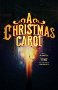 A Christmas Carol in bright, ornate gold font above a lit candle illuminating a passageway.